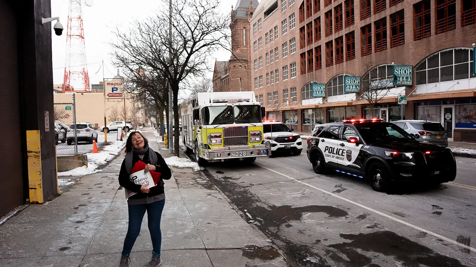 A woman holds a STOP-DWI New York sign as the Lights On For Life motorcade lines up on a downtown Rochester street