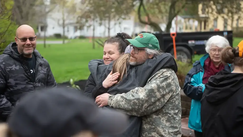 Two RAID members embrace at the memorial garden planting