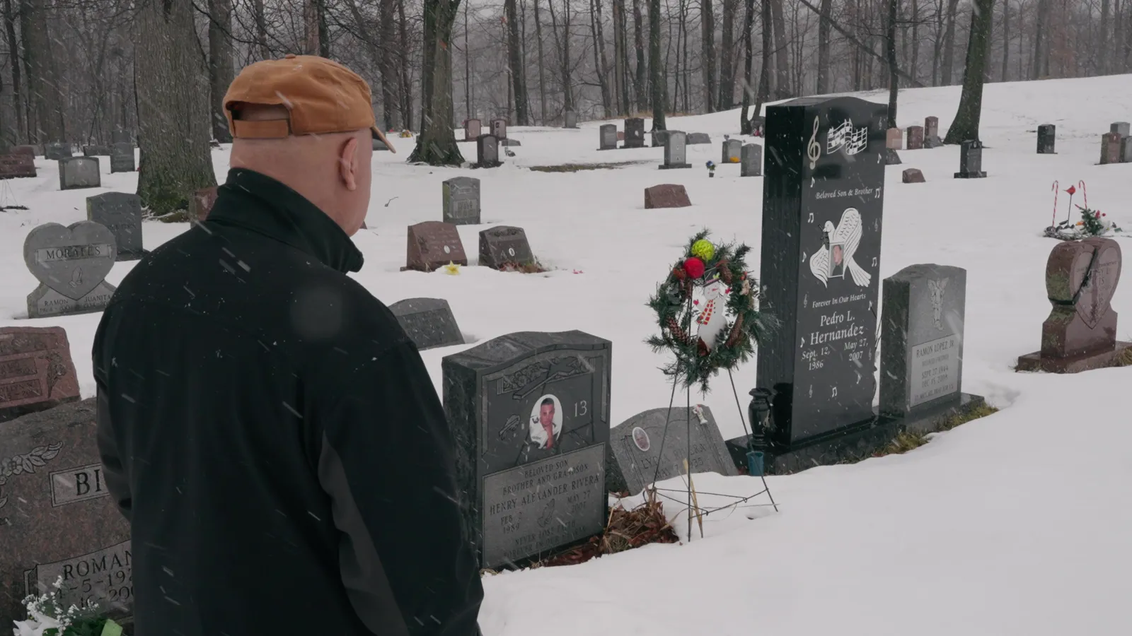 Henry Rivera Sr. at his son's grave in winter